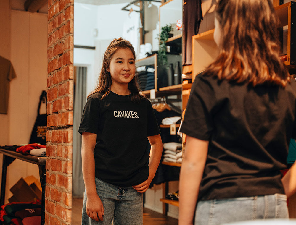 Meisje met een zwarte T-shirt met opdruk CAVAKES.