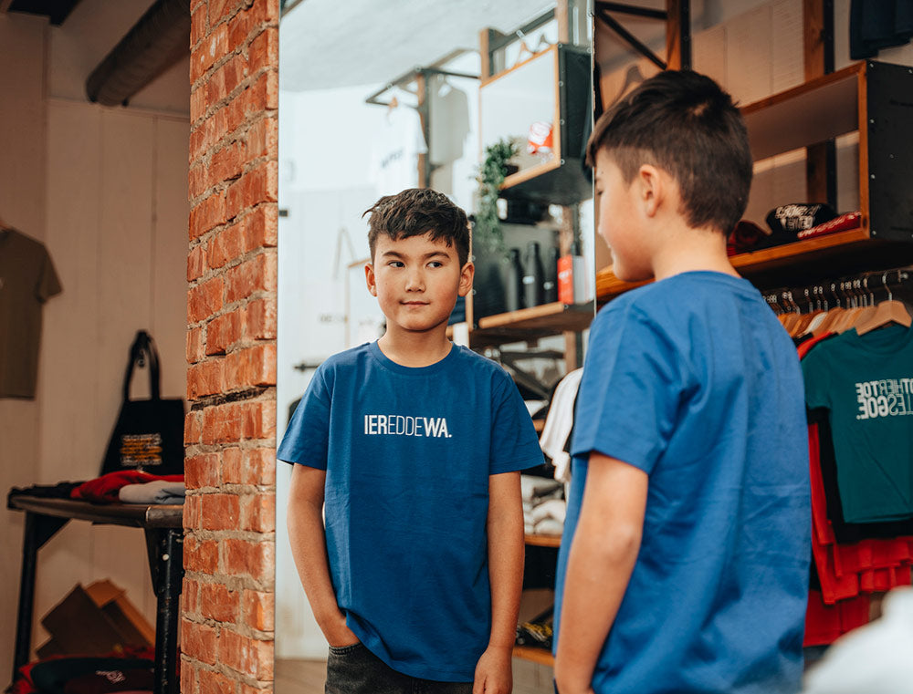 Jongen met een blauwe T-shirt met opdruk IEREDDEWA.
