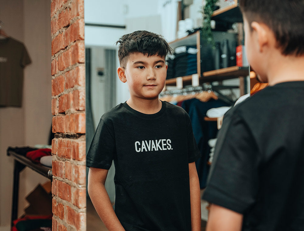 Jongen met een zwarte T-shirt met opdruk CAVAKES.