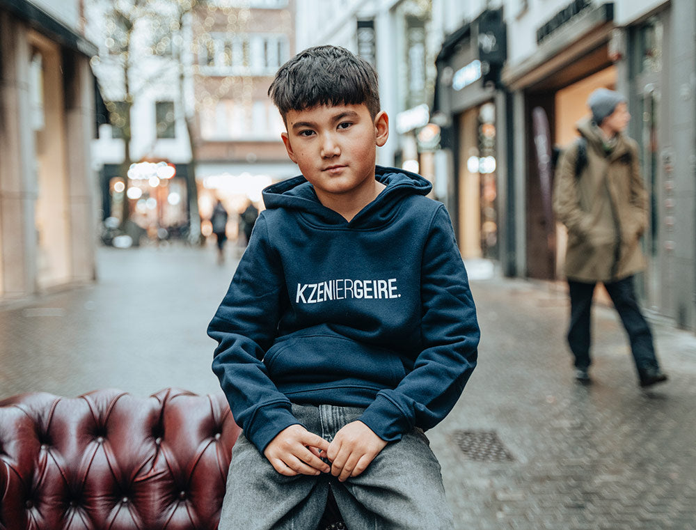 Jongen met donkerblauwe hoodie met opdruk KZENIERGEIRE.