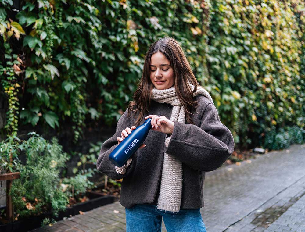 Vrouw met een donkerblauwe drinkfles met opdruk KZENTMUUG.