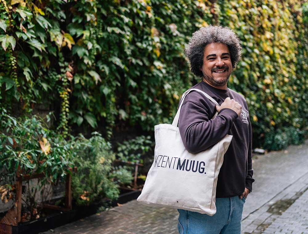 Man met een totebag met opdruk KZENTMUUG.