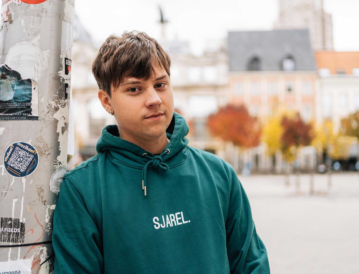 Man met een groene hoodie met opdruk SJAREL.
