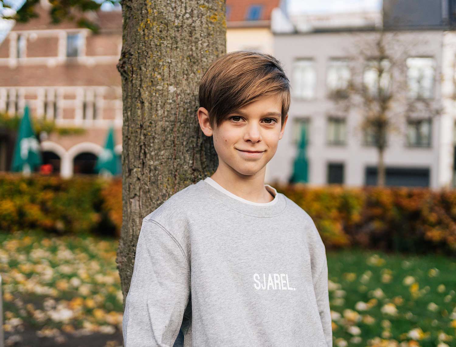 Jongen met een grijze sweater met opdruk SJAREL. voor kinderen