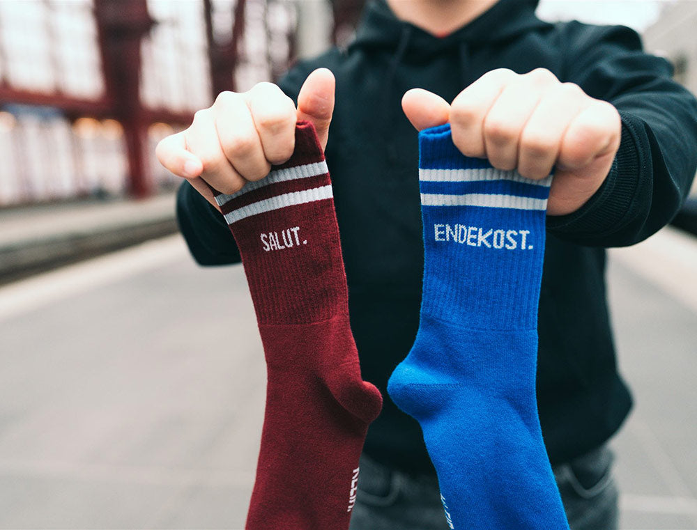 Rode sok met opdruk SALUT. Blauwe sok met opdruk ENDEKOST.