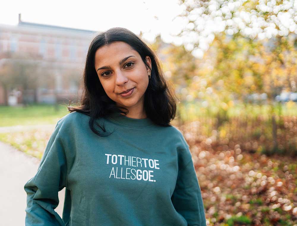 Vrouw met een groene trui met opdruk TOTHIERTOEALLESGOE.