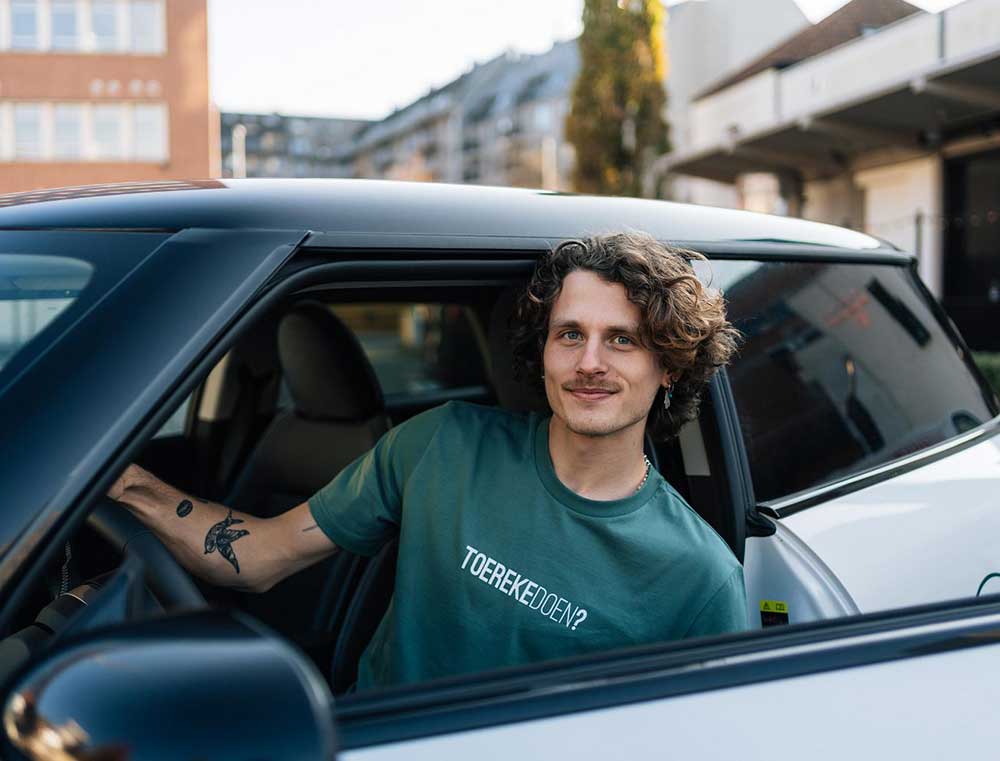 Man met een groene T-shirt met opdruk TOEREKEDOEN?