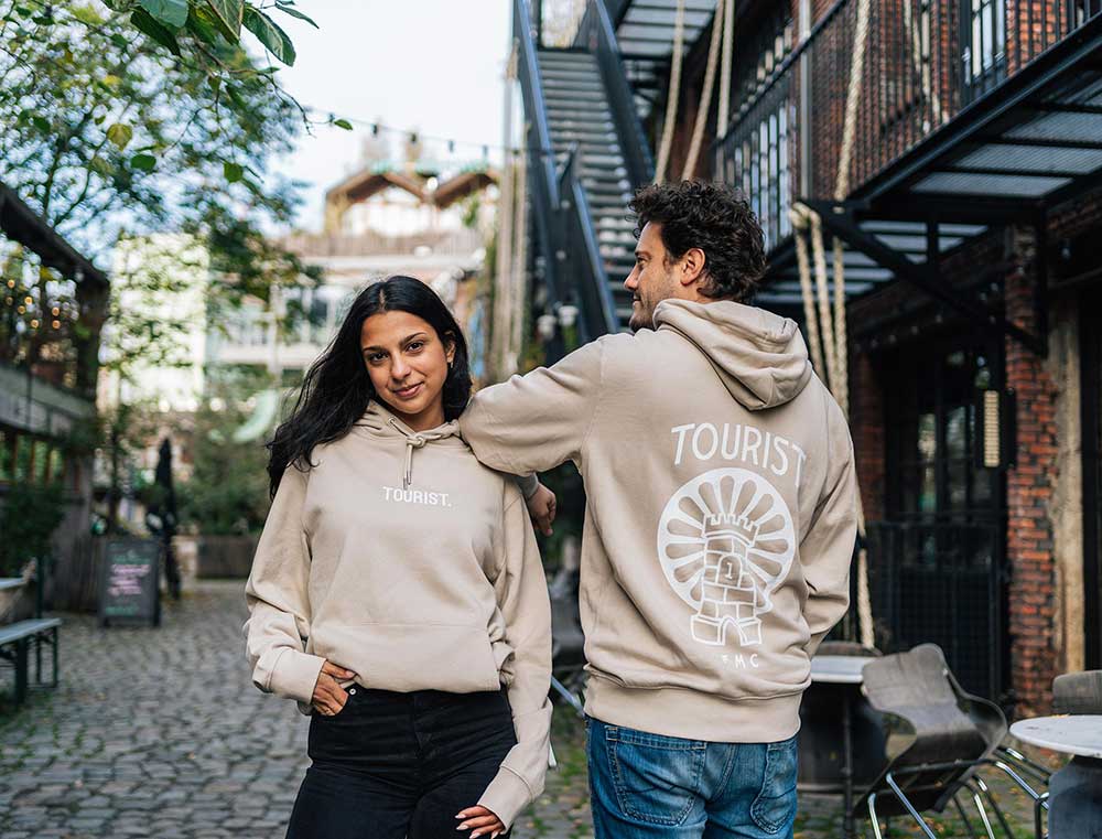 Een man en een vrouw met de voor- en achterkant van de hoodie.