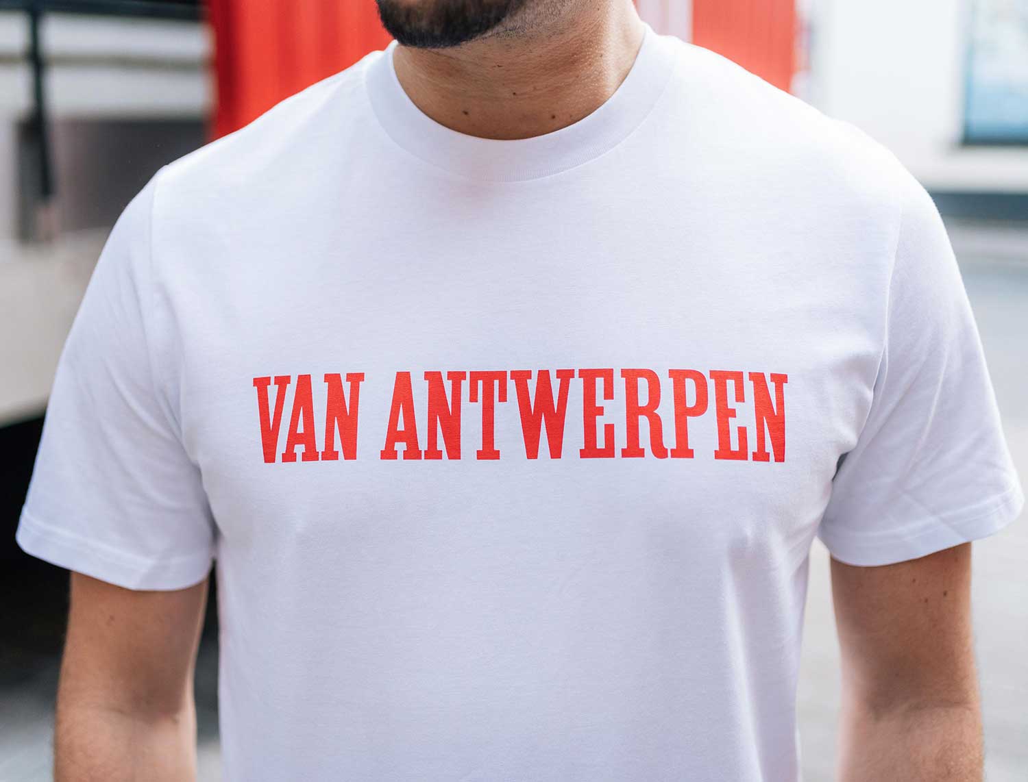 Close-up van een witte T-shirt met opdruk Van Antwerpen in de typische GVA letters.