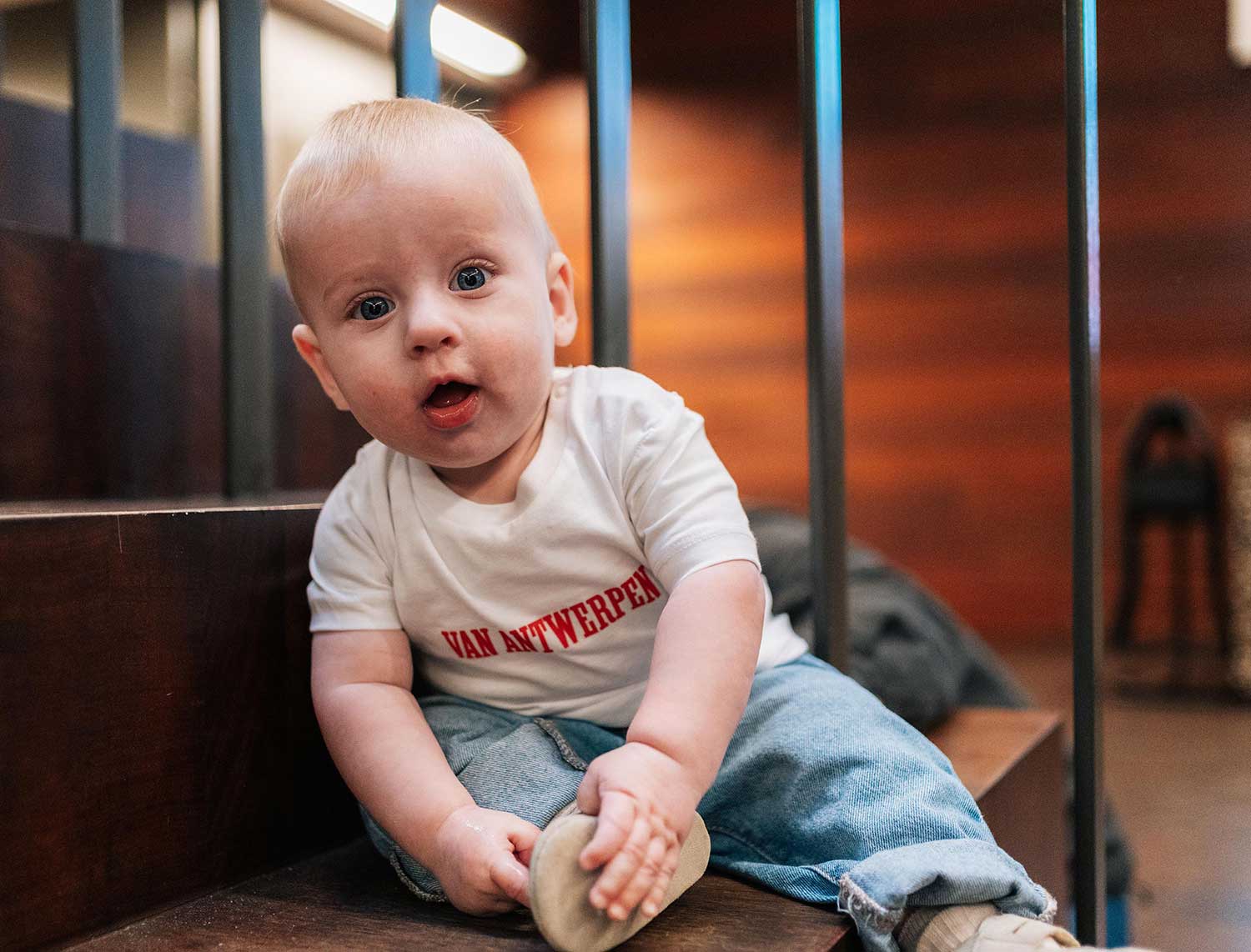 Baby met een witte T-shirt met opdruk Van Antwerpen