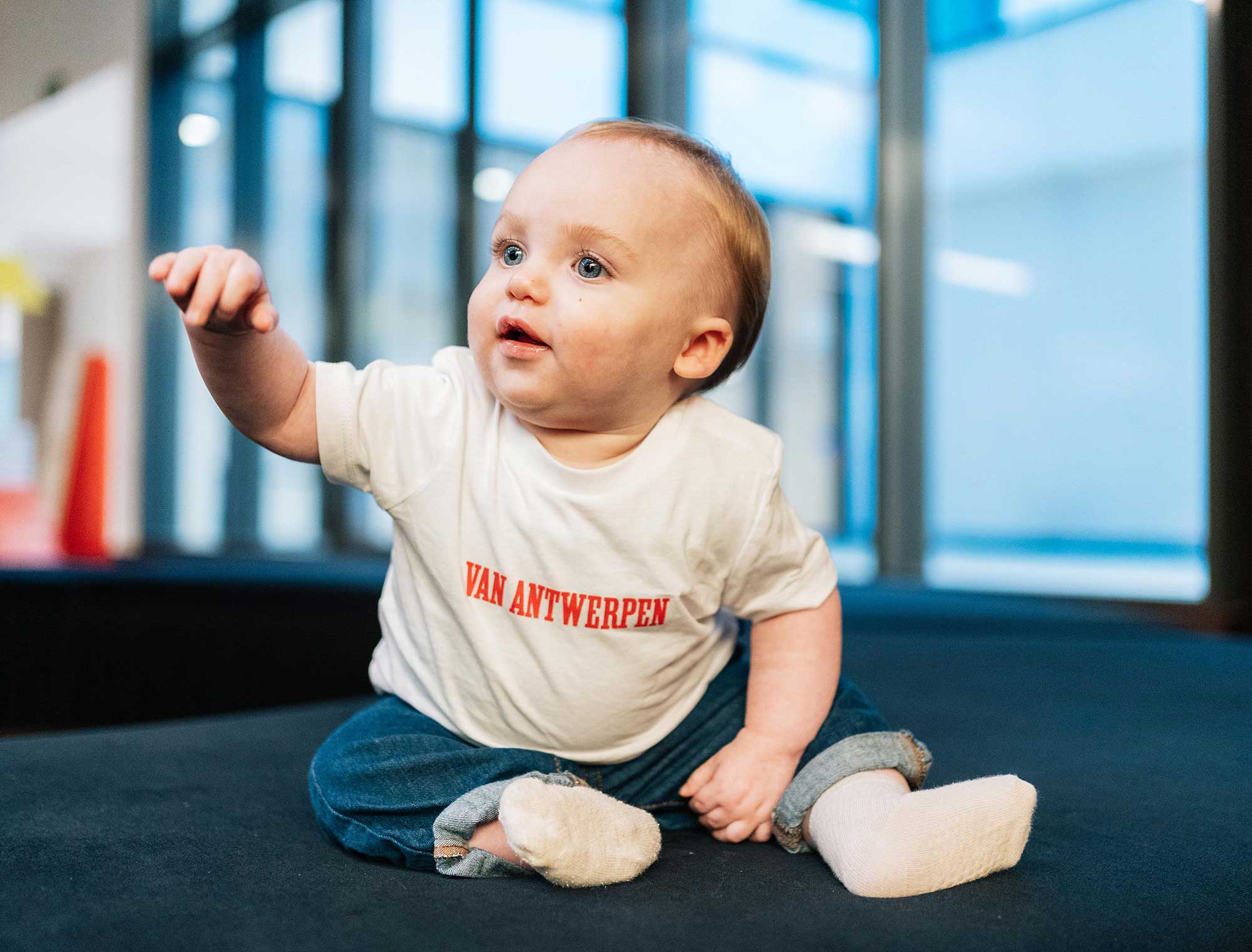 Baby met een witte T-shirt met opdruk Van Antwerpen