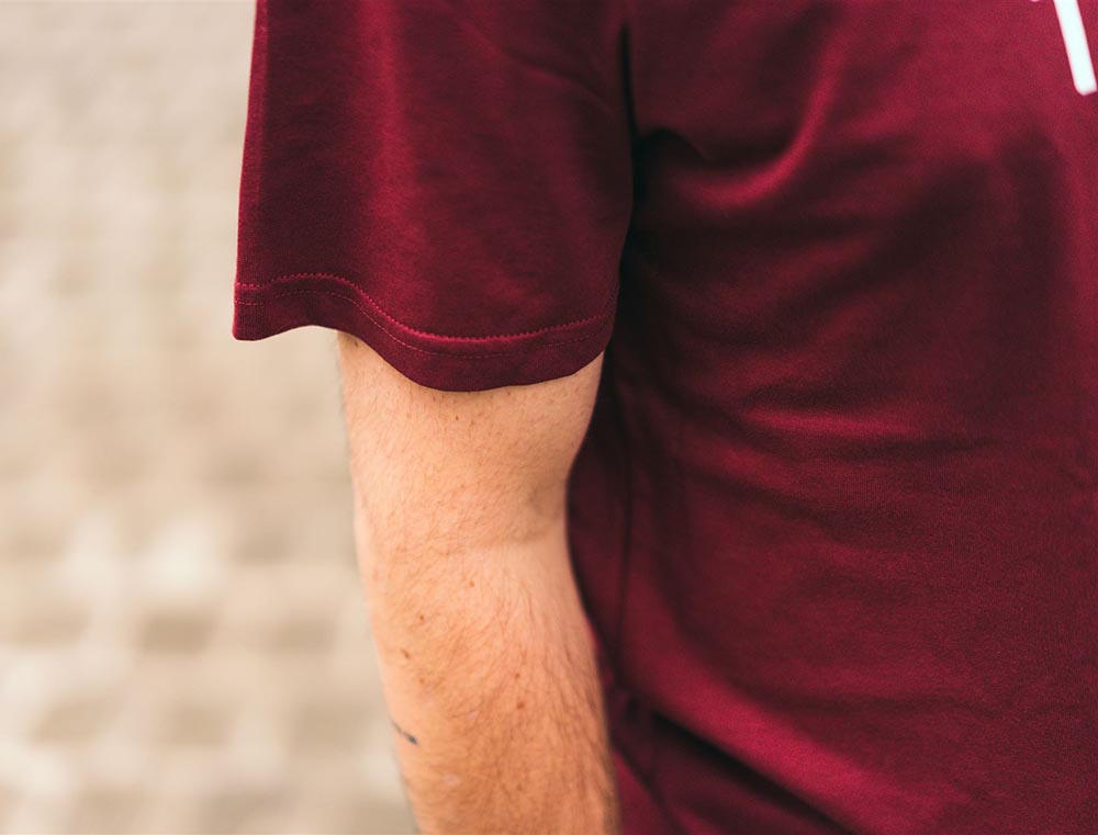 Close-up van bordeaux T-shirt met opdruk TOETERNITOE.