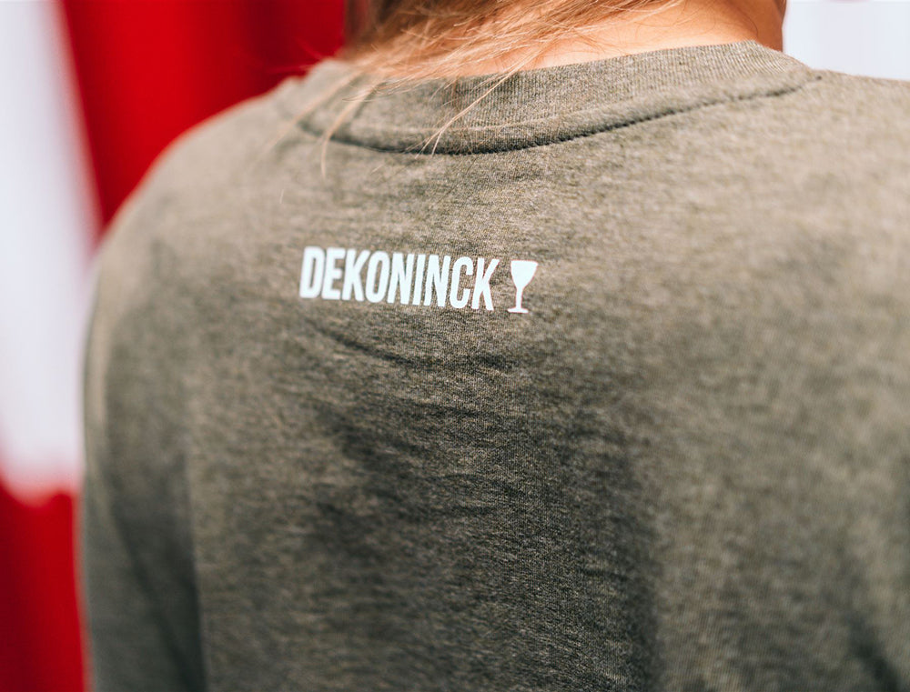 Close-up van de achterkant van een kaki T-shirt met logo van De Koninck.