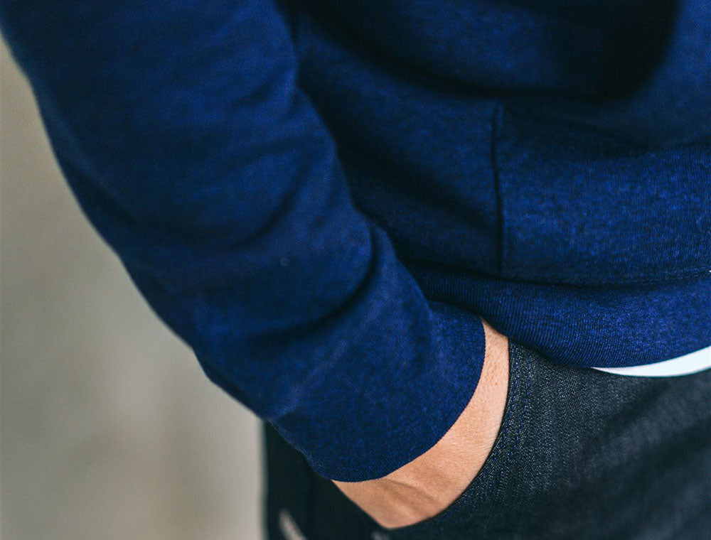 Close-up van de mouw van een donkerblauwe hoodie.