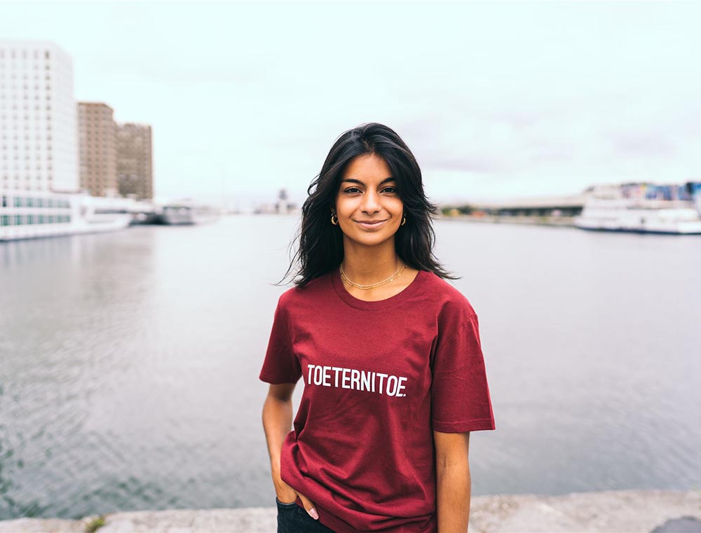 Vrouw met bordeaux T-shirt met opdruk TOETERNITOE.