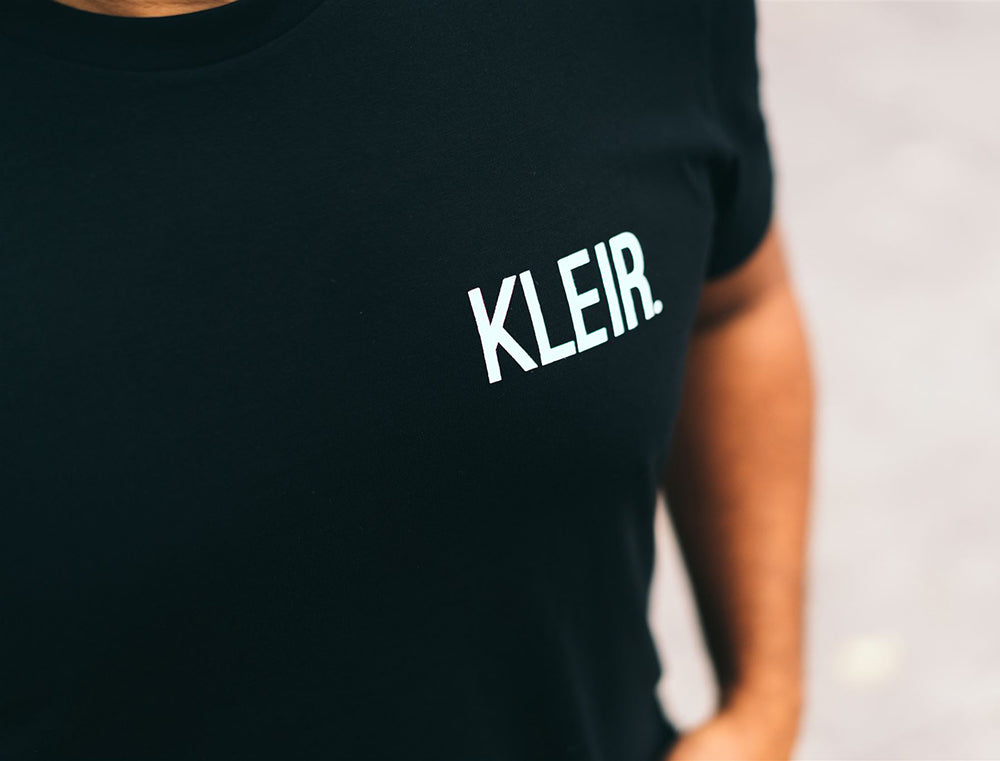 Close-up van zwarte T-shirt met opdruk KLEIR.