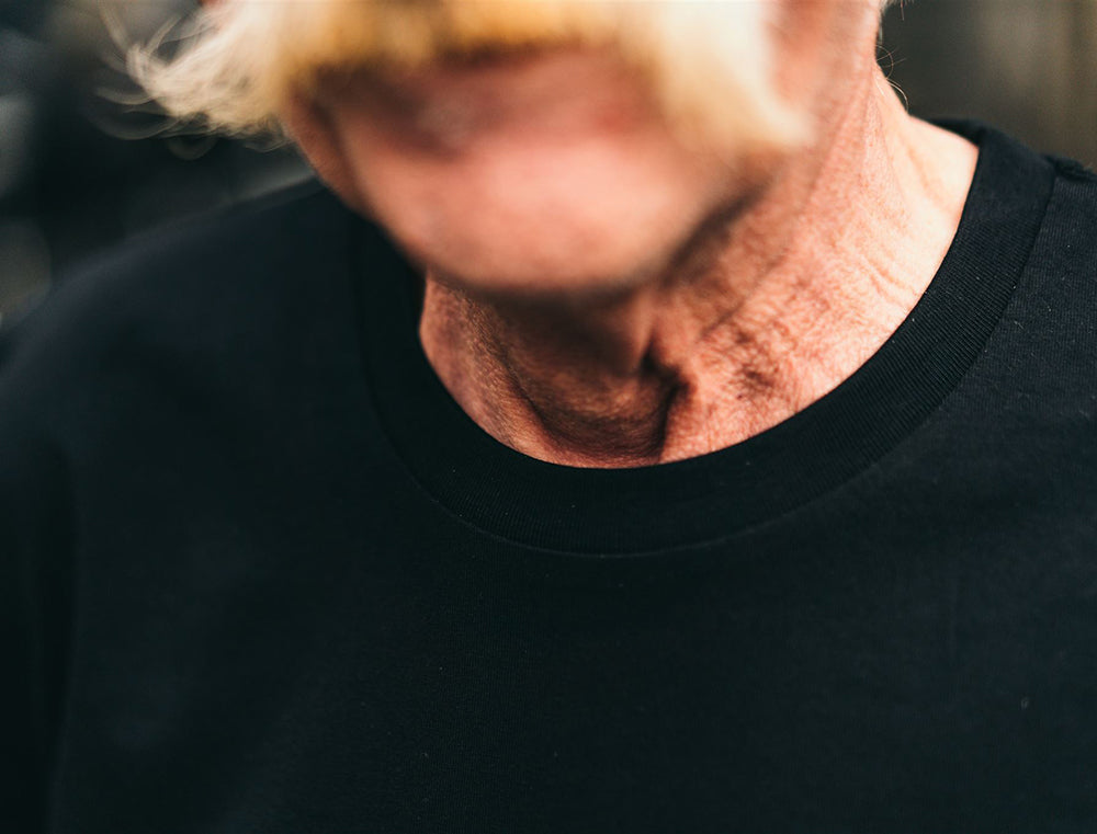 Close-up van een zwarte T-shirt met opdruk EERSTNEKOFFE.