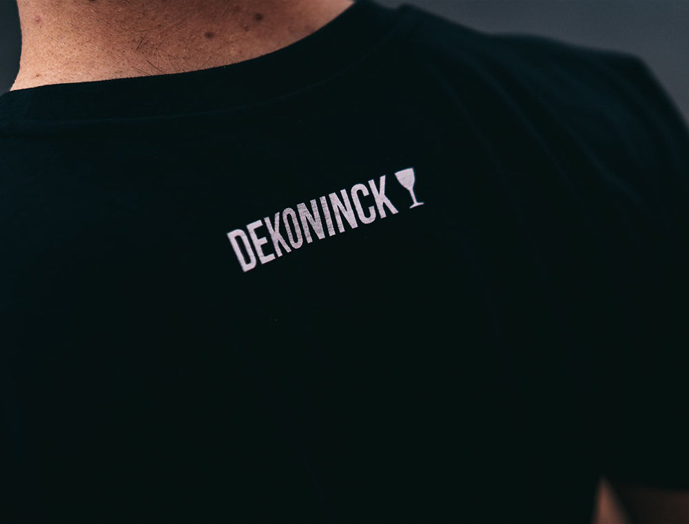 Detail van een T-shirt nek met het logo van De Koninck