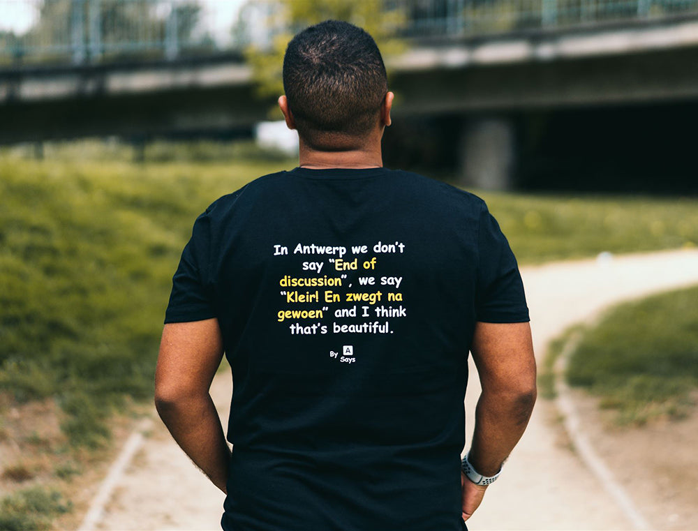 Man met zwarte T-shirt met geel/witte opdruk.