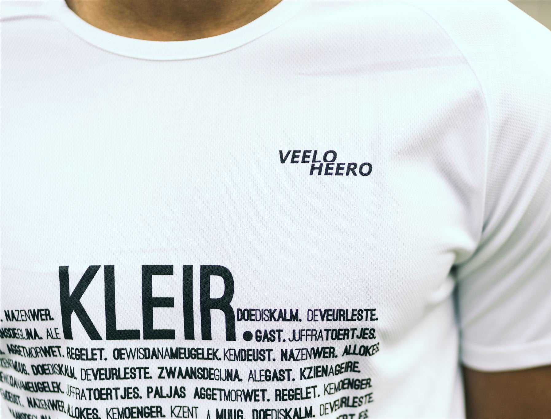 Close-up van een wit loopshirt met opdruk KLEIR.