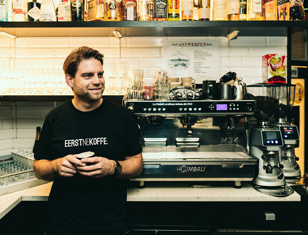 Man met zwarte T-shirt met opdruk EERSTNEKOFFE.