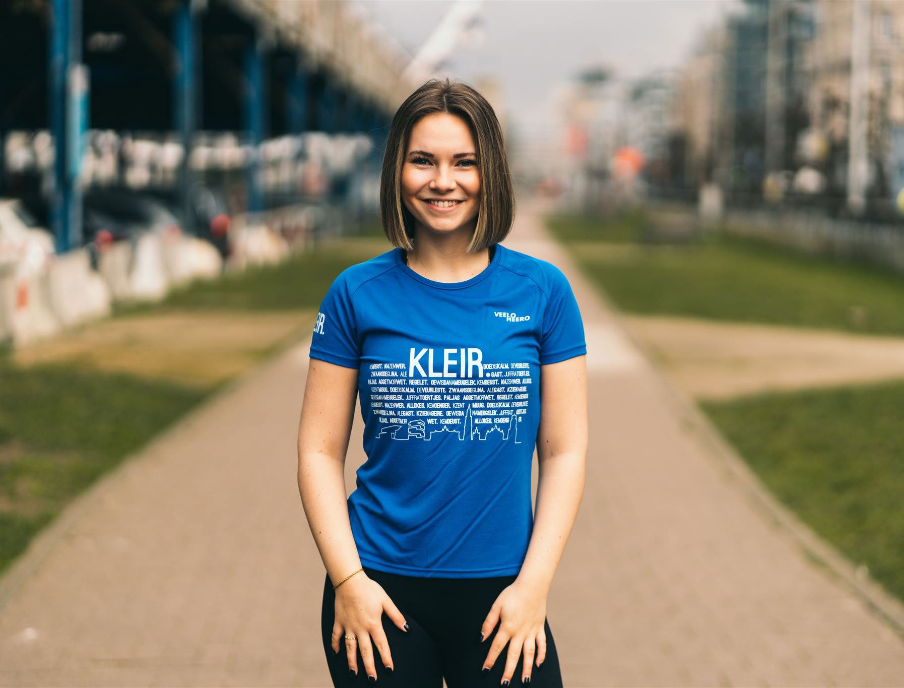 Vrouw met blauw loopshirt met opdruk KLEIR.