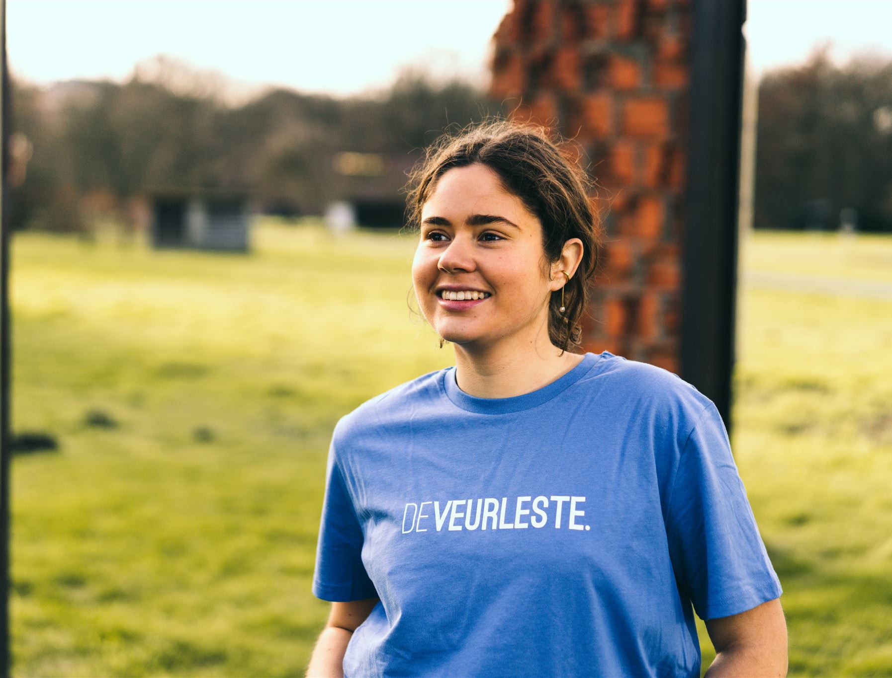 Vrouw met een blauwe T-shirt met opdruk DEVEURLESTE.