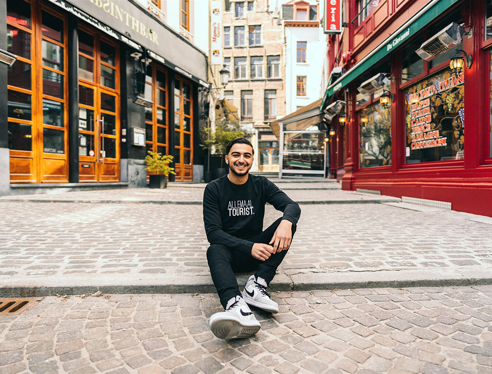 Man met zwarte trui met opdruk 'ALLEMAALTOURIST.'