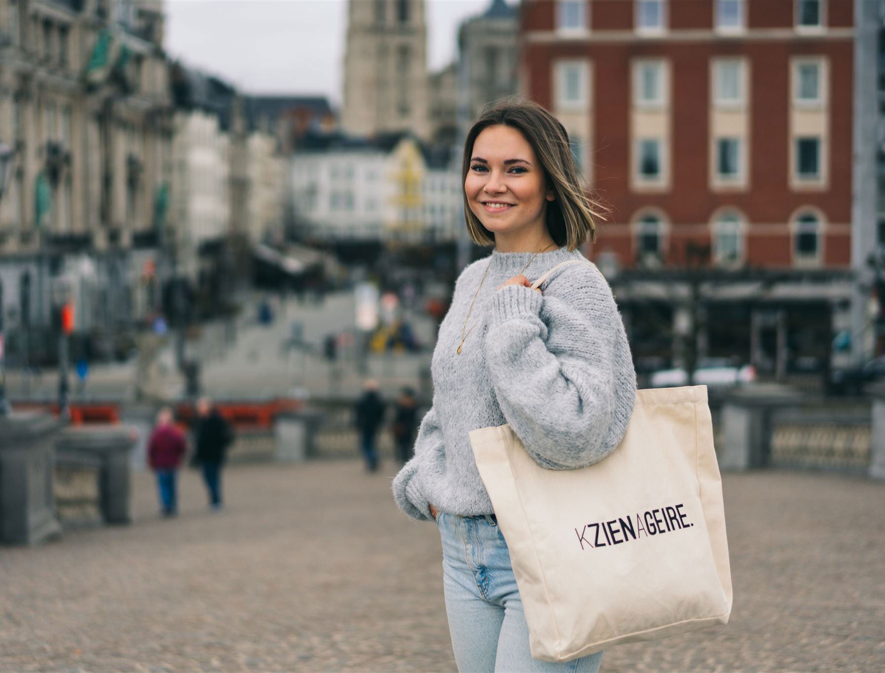 Vrouw met een totebag met opdruk KZIENAGEIRE.