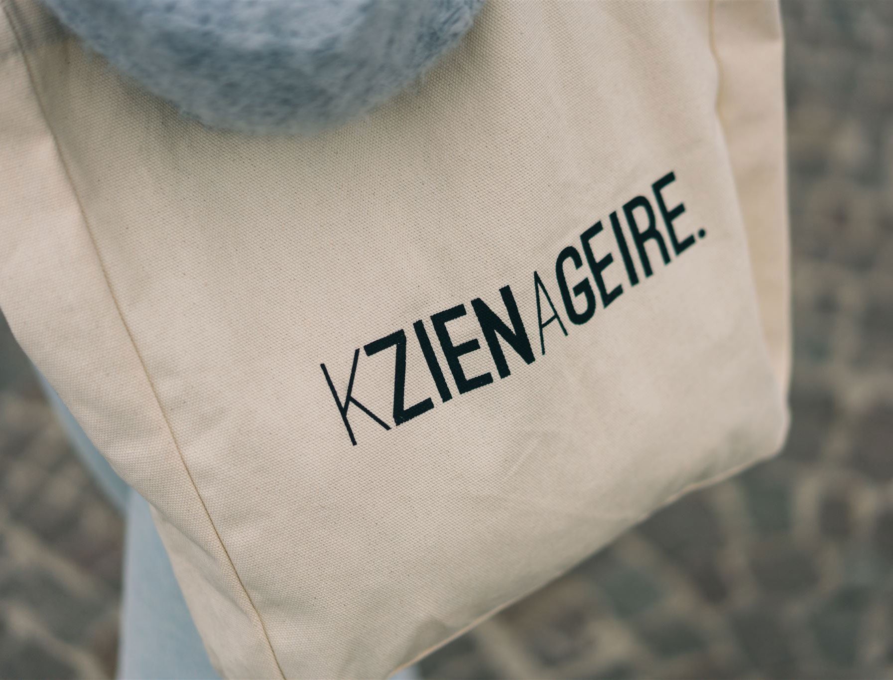 Close-up van een totebag met opdruk KZIENAGEIRE.