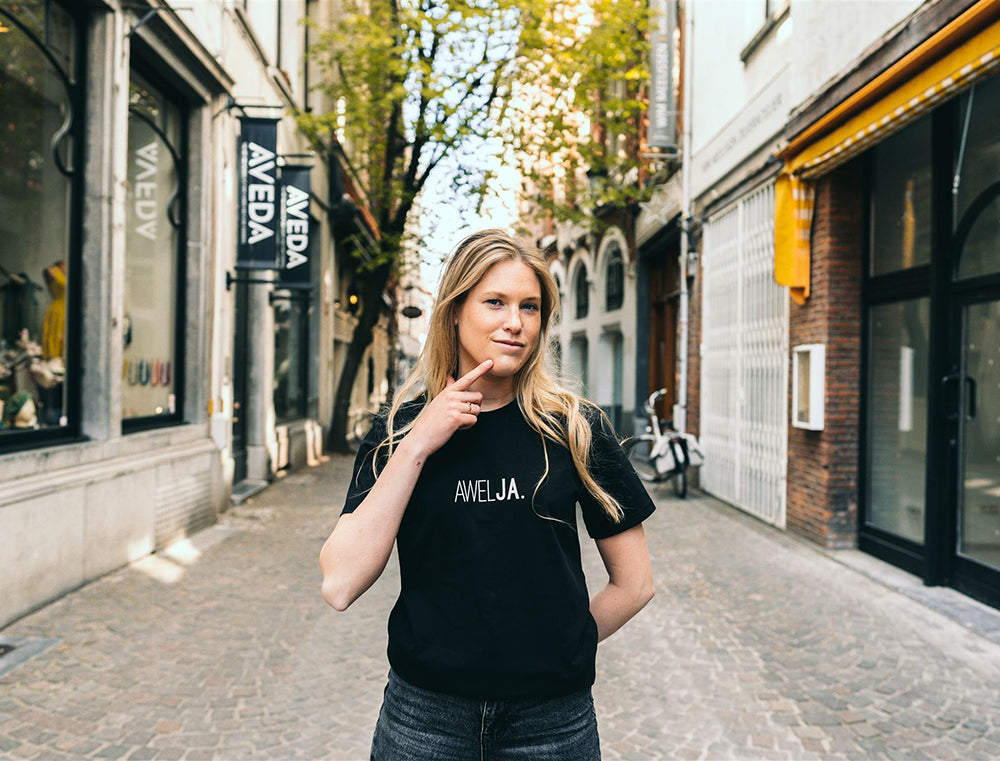 Vrouw met zwarte T-shirt met opdruk 'AWELJA.'