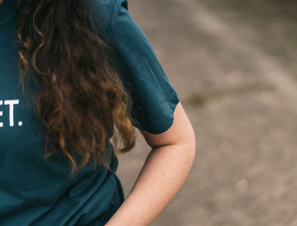 Close-up van een petrolblauwe T-shirt.
