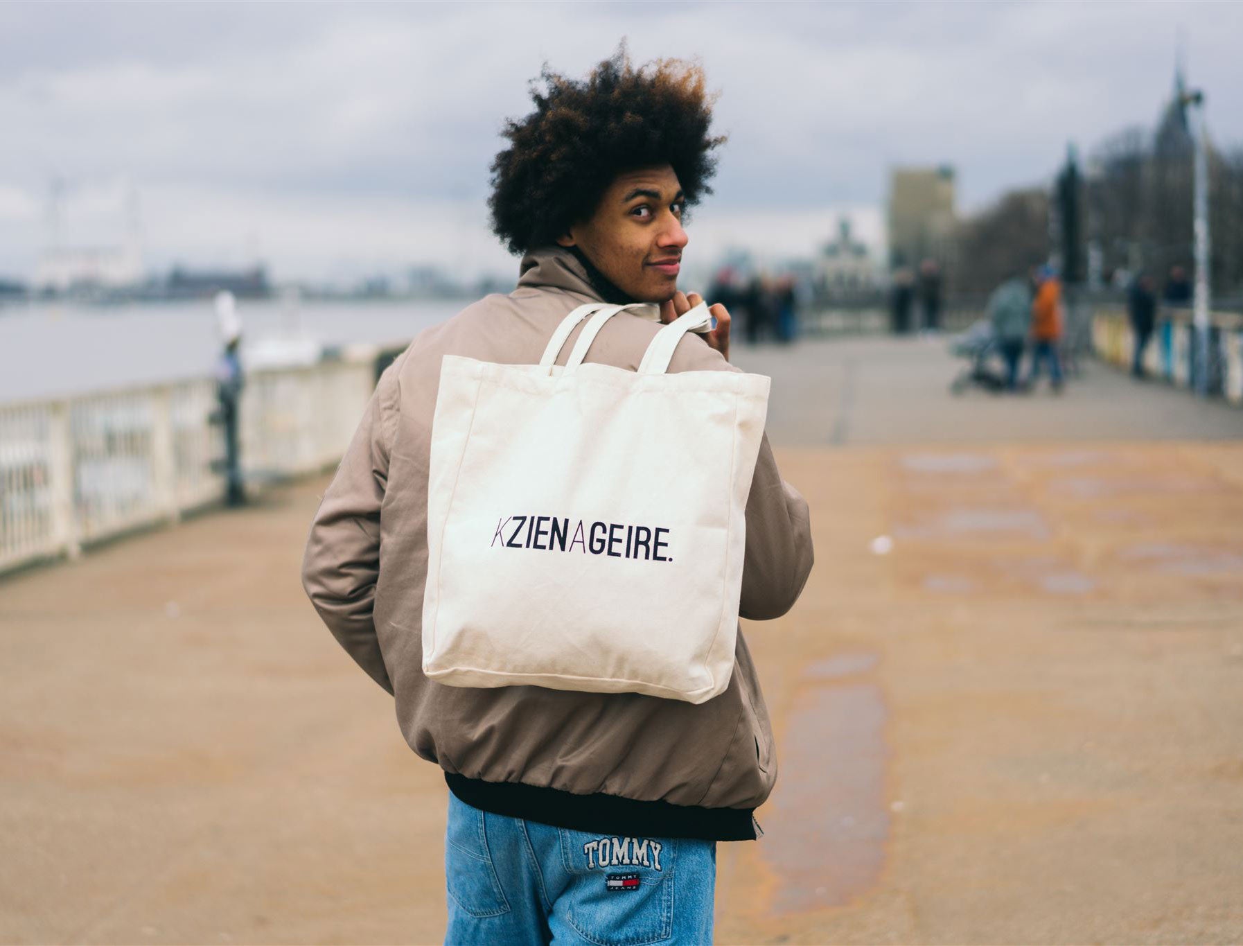 Man met een totebag met opdruk KZIENAGEIRE.