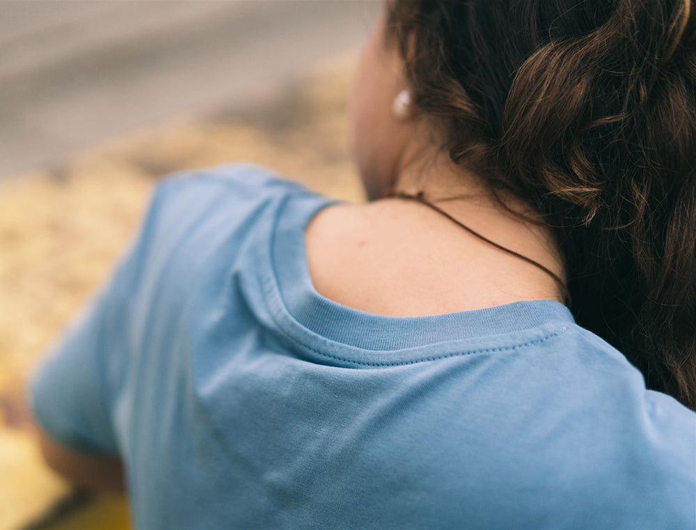 Close-up van een lichtblauwe T-shirt.