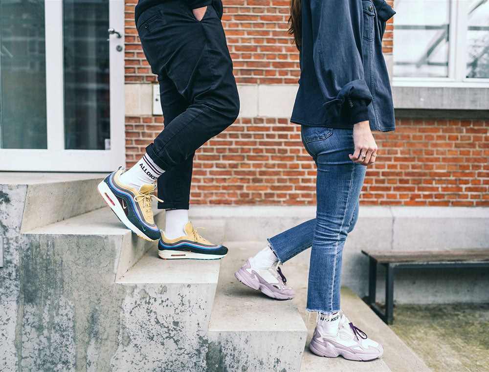 Man en vrouw op trap met sokken met opdruk ALLOKES.