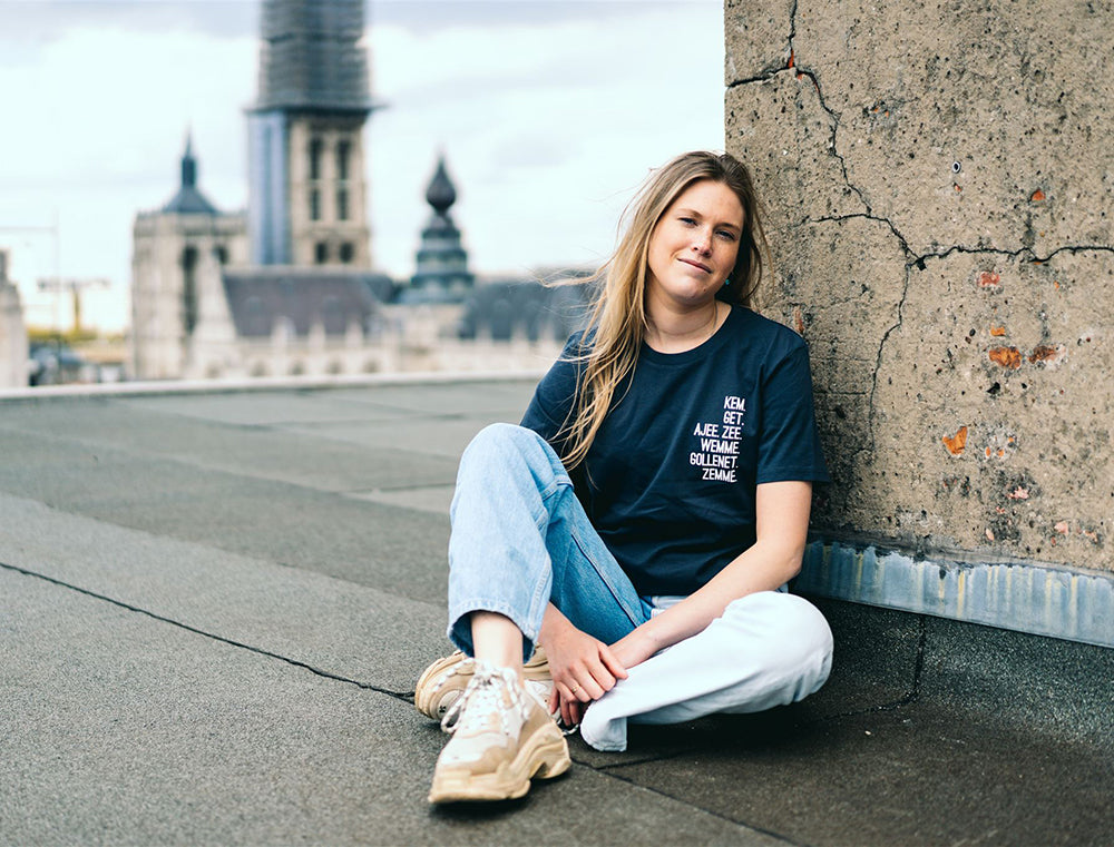 Vrouw met grijze T-shirt met de vervoeging van 'hebben' als opdruk.