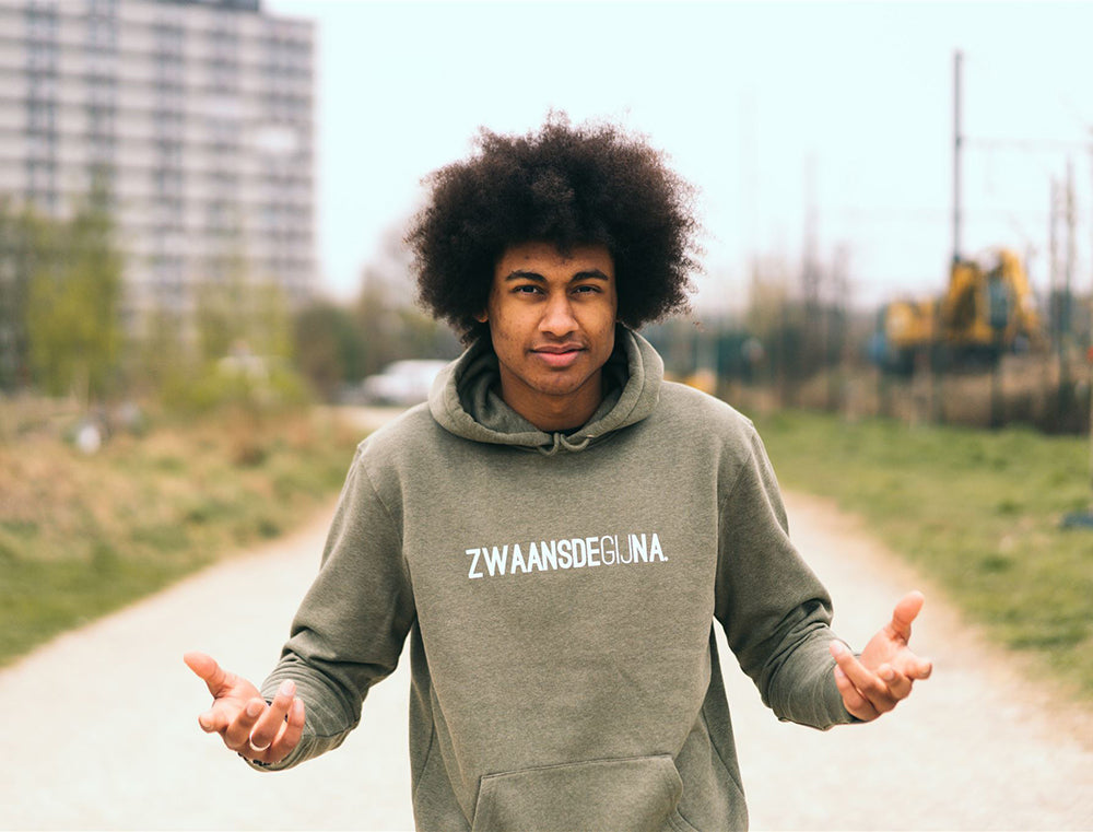 Man met kaki hoodie met opdruk ZWAANSDEGIJNA.