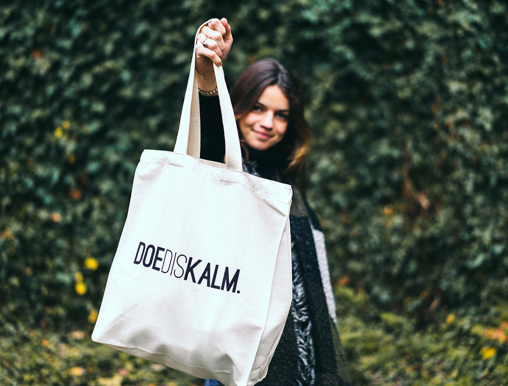 Vrouw met totebag met opdruk DOEDISKALM.