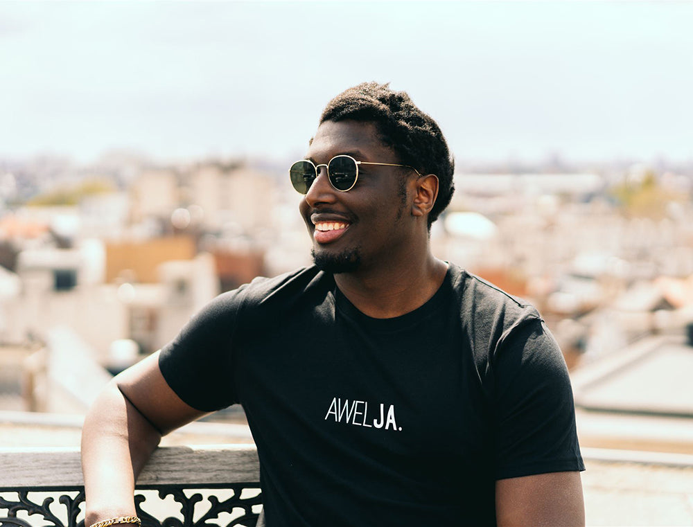 Man met zwarte T-shirt met opdruk 'AWELJA.'