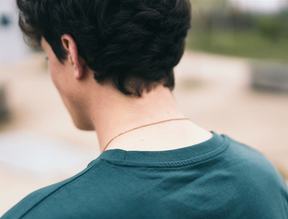 Close-up van een petrolblauwe T-shirt.