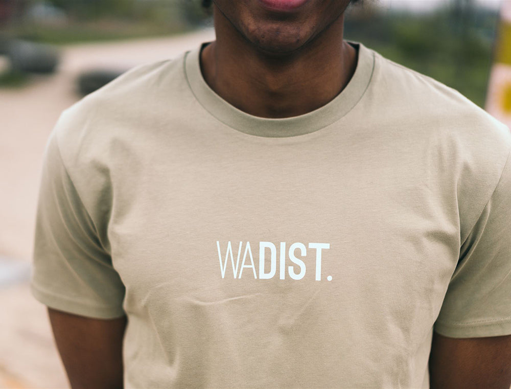 Man met sage T-shirt met opdruk WADIST.