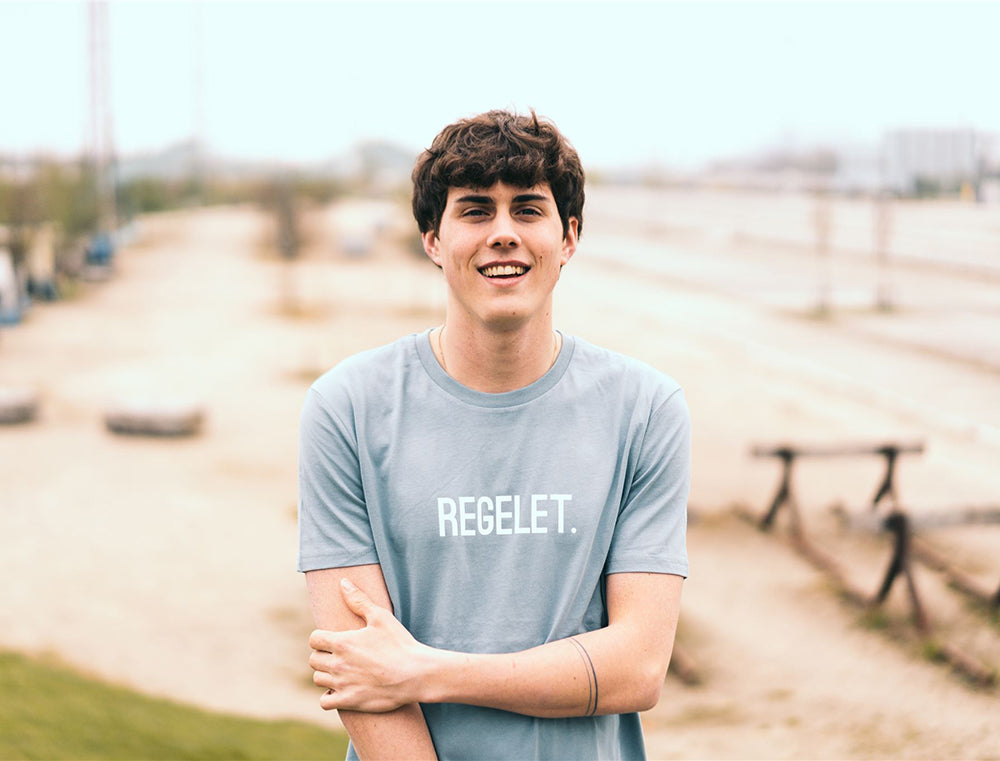 Man met lichtblauwe T-shirt met opdruk REGELET.