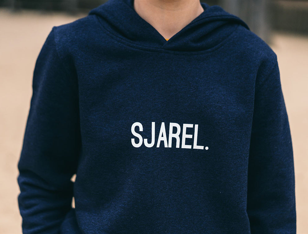 Jongen met blauwe hoodie met opdruk SJAREL.