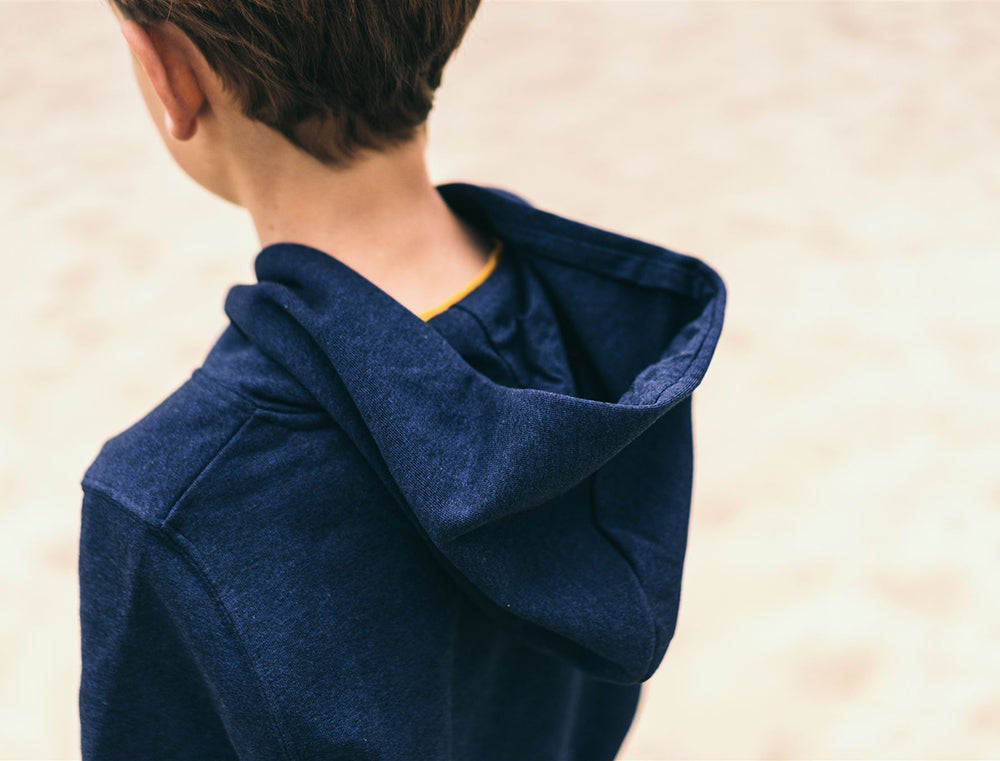 Jongen met blauwe hoodie met opdruk SJAREL.