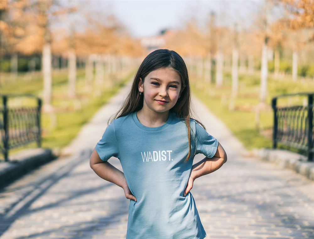 Meisje met een lichtblauwe T-shirt met opdruk WADIST.