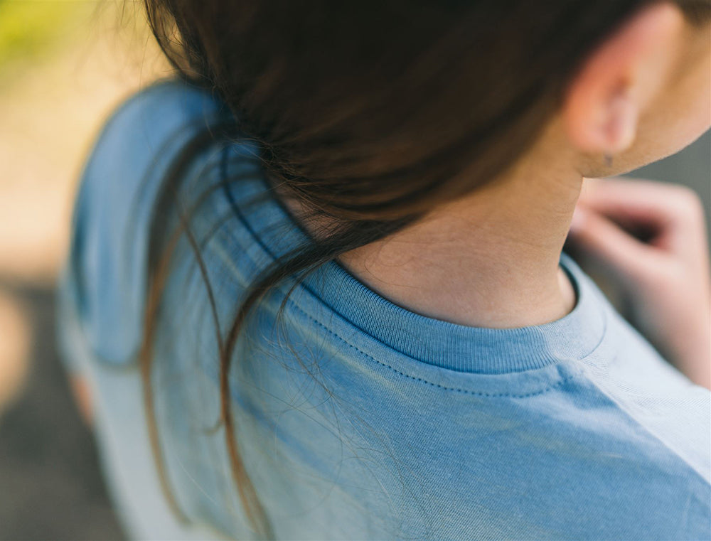Close-up van een lichtblauwe T-shirt.