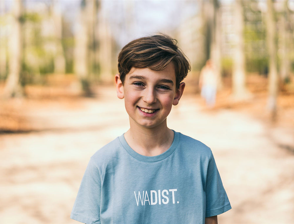 Jongen met lichtblauwe T-shirt met opdruk WADIST.