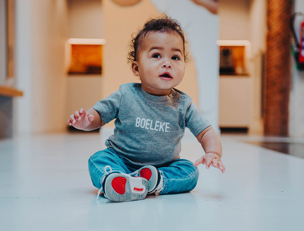 Jongen met grijze T-shirt met opdruk BOELEKE.