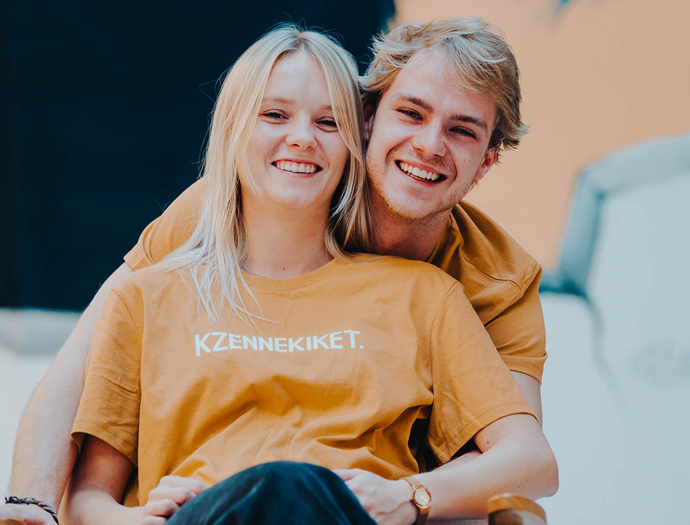 Man en vrouw met oker-kleurige T-shirt met opdruk KZENNEKIKET.