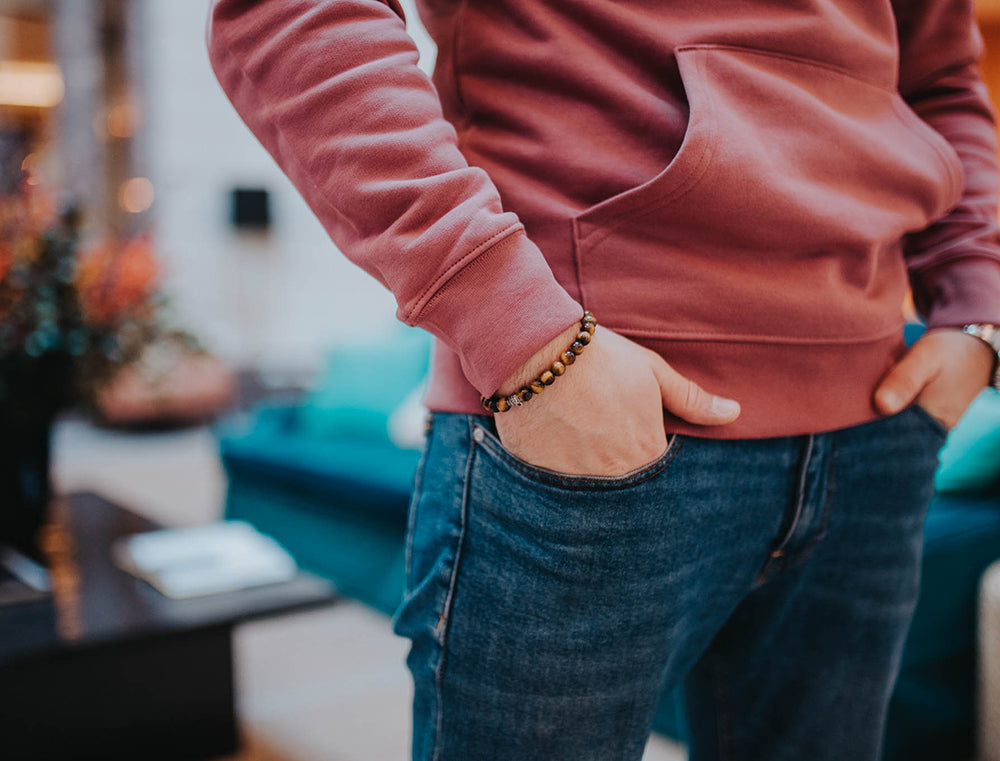 Close-up van een bordeaux hoodie met opdruk KEMDEUST.